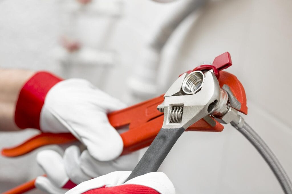 Plumber holding pipe wrenches for an emergency repair in Plant City