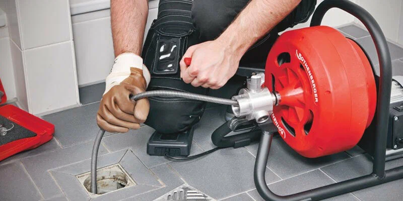 Plumber using a drain-cleaning machine in Plant City