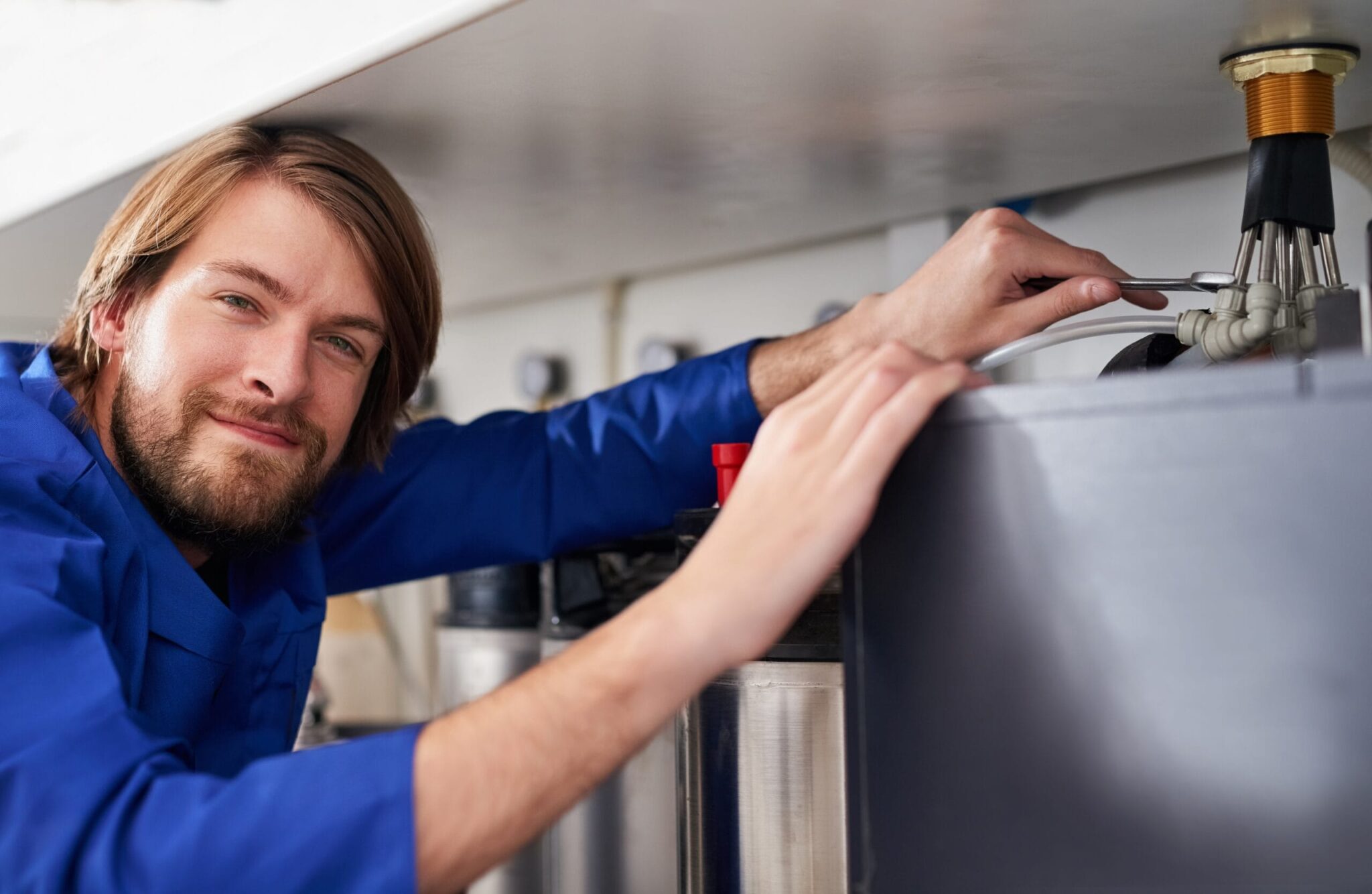 Technician servicing a residential water heater tank in Plant City